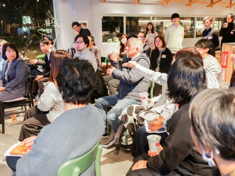 客席から登壇者に向けて、手話で会話するろうの参加者。会場では、手話と音声日本語が入り混じった議論が白熱した。